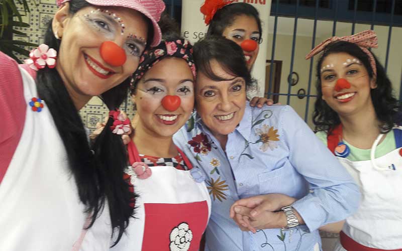 Imagem ilustrativa da equipe em uma festa a fantasia com nariz de palhaço para alegrar a festa na casa de repouso mamma mia