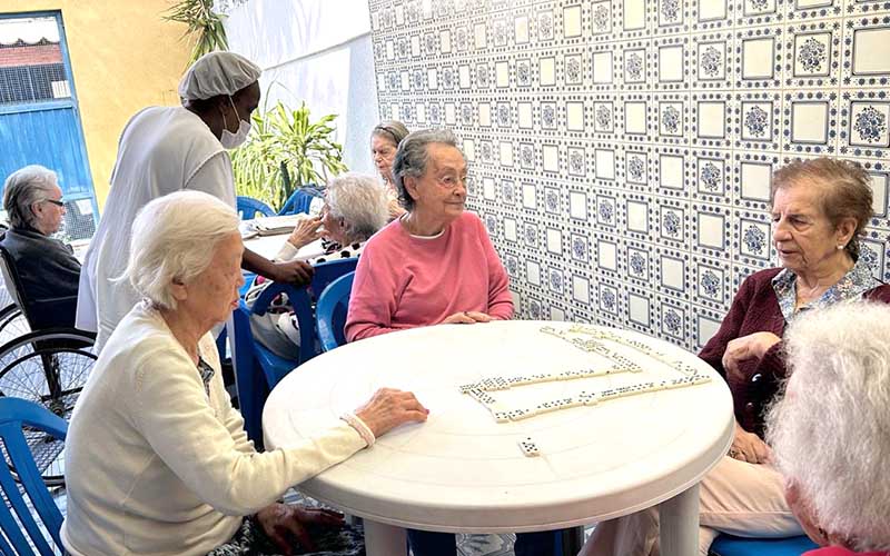 Imagem ilustrativa de atividades de jogos como dominó no quintal da casa de repouso mamma mia